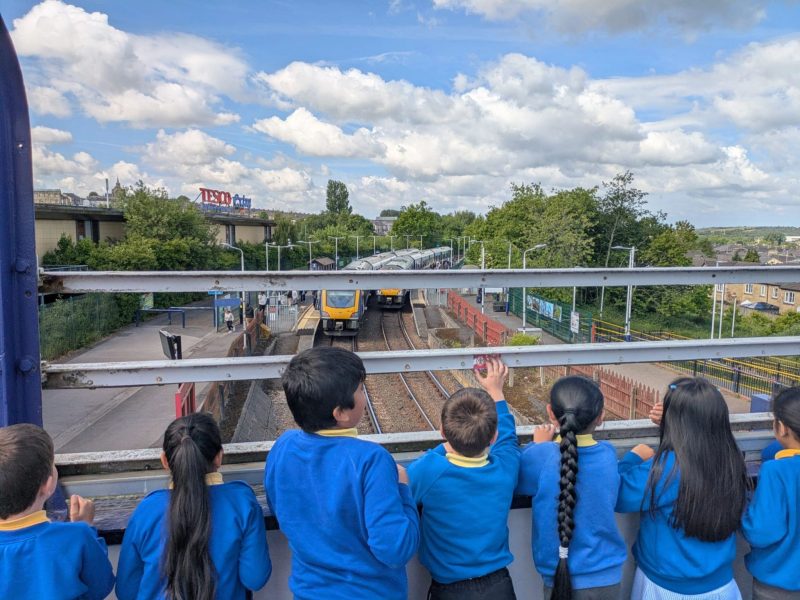 Pupils waving at a train at Accrington Station