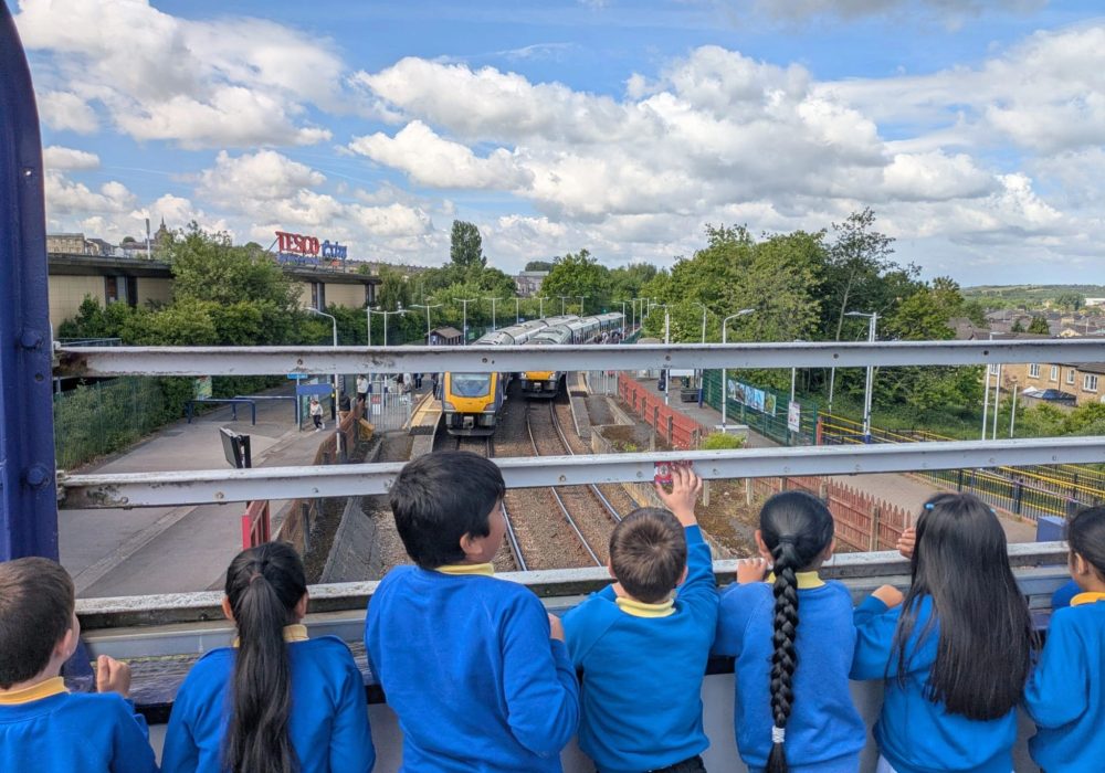 Pupils waving at a train at Accrington Station